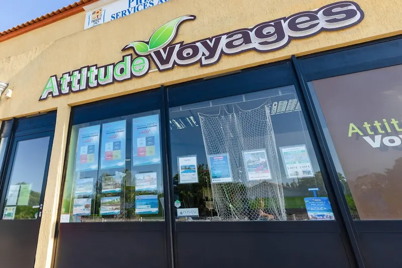 Façade de l’agence Attitude Voyages à Caveirac : l’enseigne au-dessus de la vitrine, où sont affichées les offres de séjours