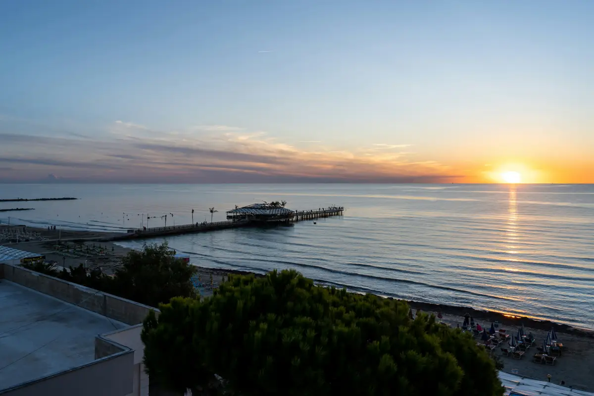 Le soleil au ras de l’horizon sur l’Adriatique à Durrës, avec un ponton qui s’avance dans la mer