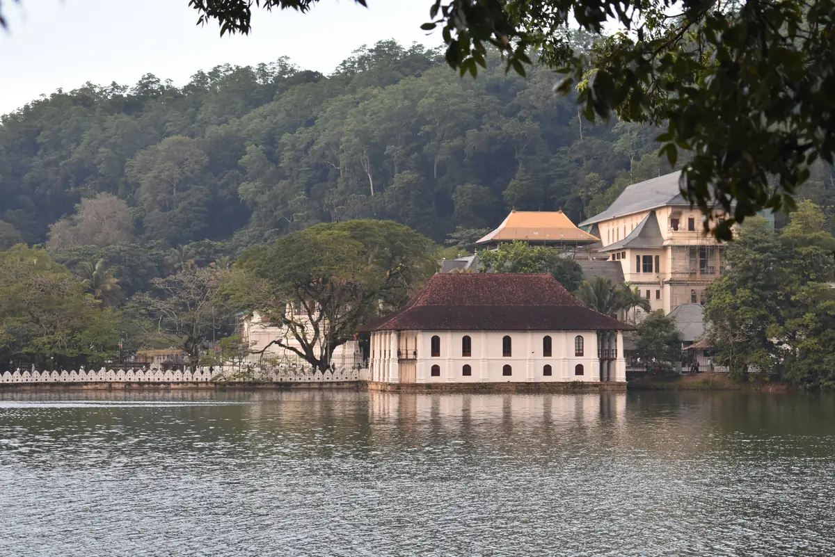 Un pavillon blanc au bord du lac de Kandy, devant les collines boisées
