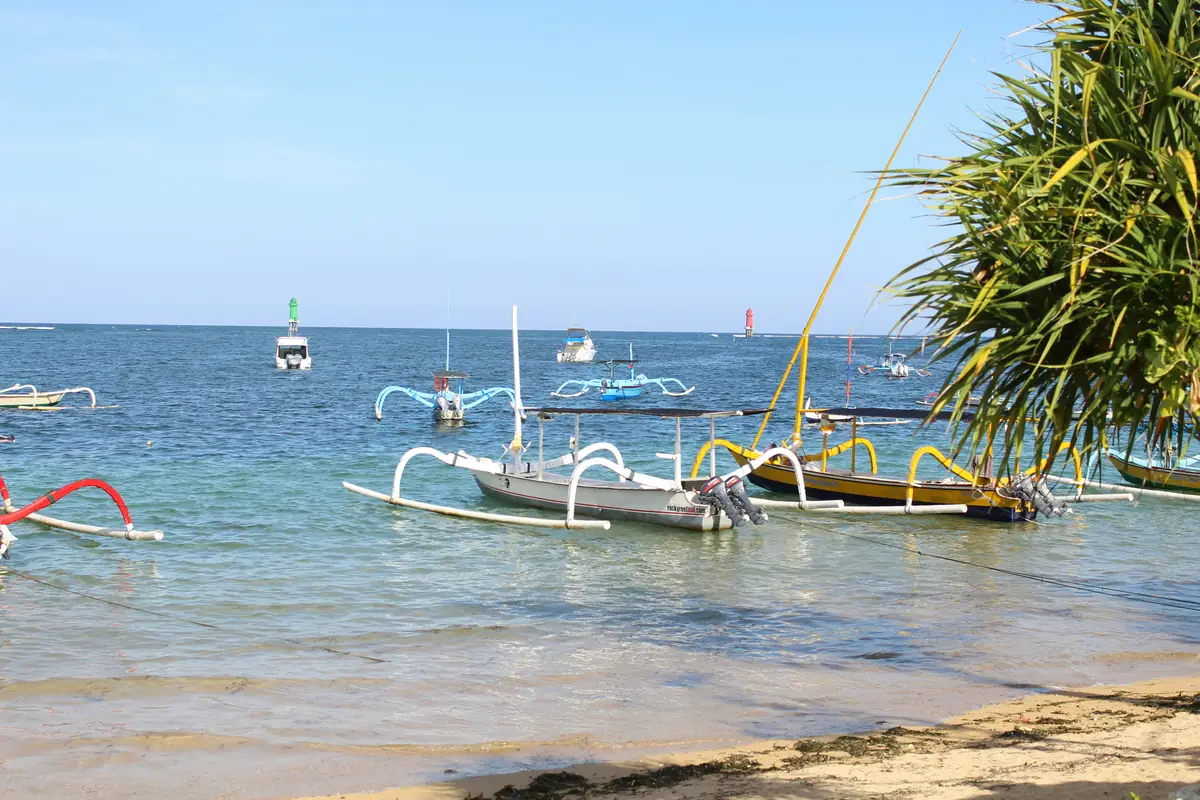 Des jukungs colorés au mouillage dans l’eau calme et peu profonde du lagon de Sanur