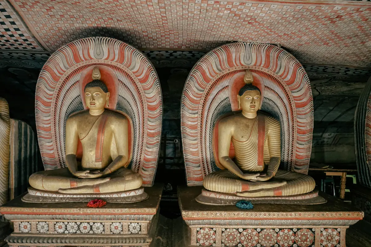 Deux bouddhas assis sous des arches peintes dans le temple rupestre de Dambulla